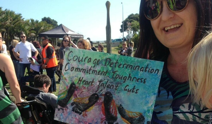 Martha shows off some of Falcon’s artwork while attending the Taranaki Hikoi for New Zealanders with disabilities.