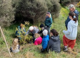 John Wraight and Nicole Thompson with family members plant a totara for Megan.